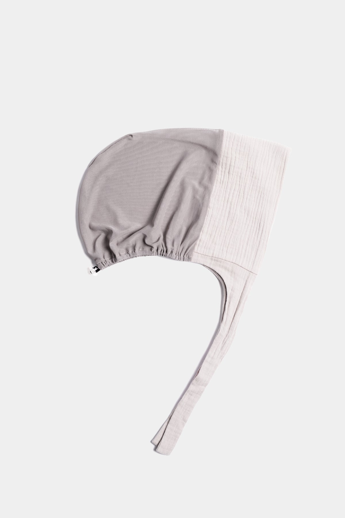 a light grey  textured cotton mesh underscarf  with ties shown flat against a light gray background.